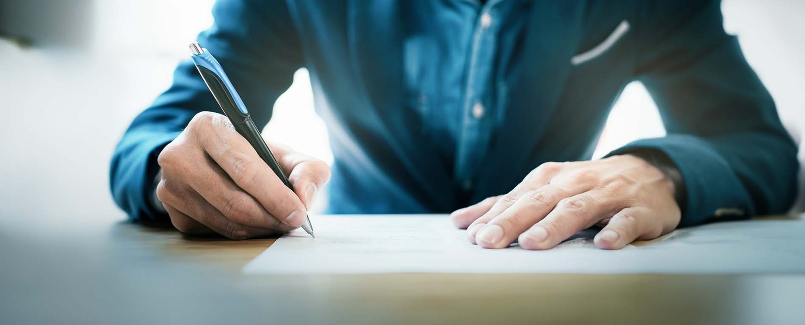 Image of man signing document